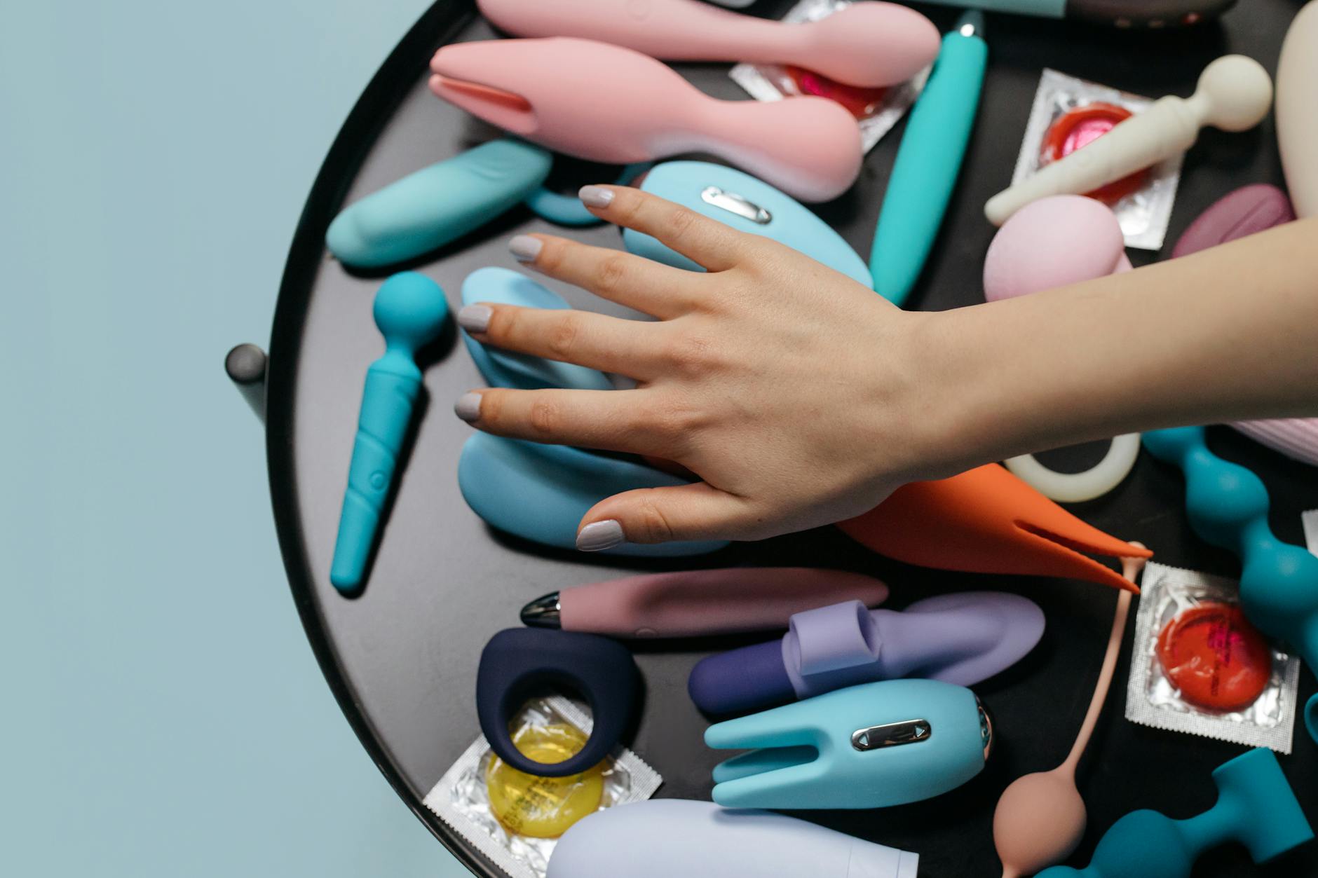 A hand holding a vibrator against a minimalistic purple backdrop, representing modern pleasure exploration.