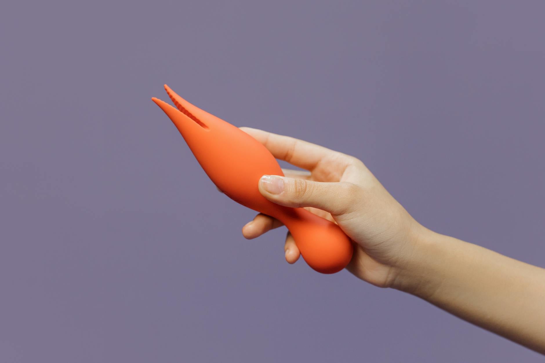 Close-up of a lemon vibrator held against a minimalist purple backdrop, showcasing modern sensual design