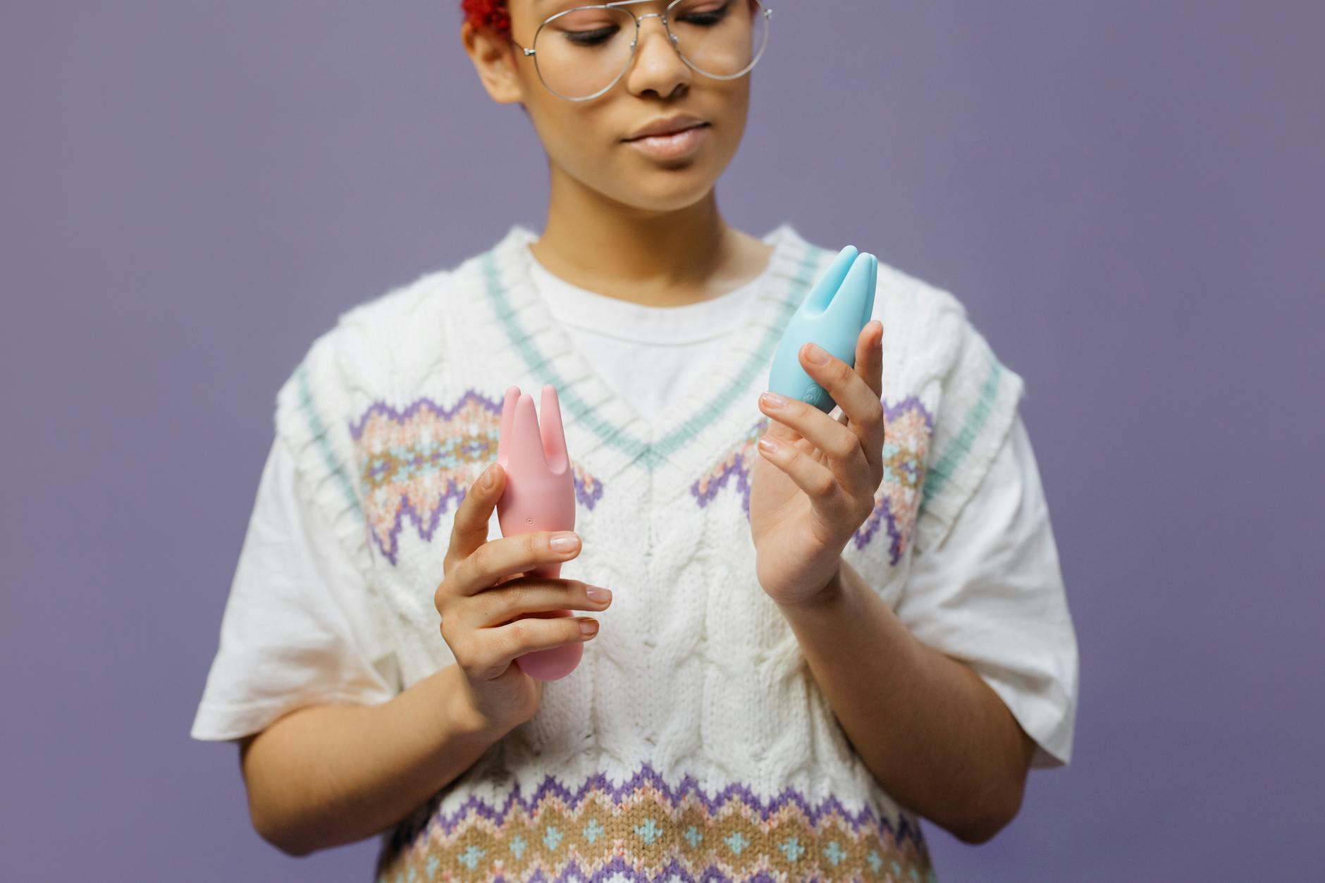 Woman holding a blue silicone vibrator with contemplative expression, representing personal pleasure and partnered intimacy
