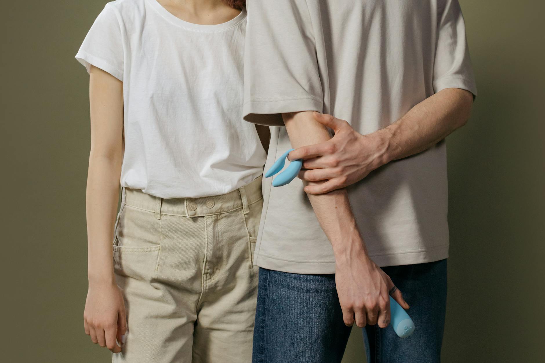 A blue silicone clitoral vibrator held in hand, highlighting sensory pleasure and wellness