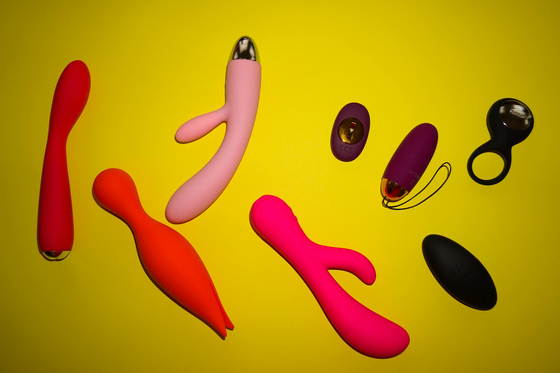 Close-up of hands holding a sleek vibrator against a purple background